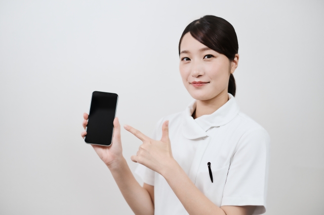 スマホを指さす女性