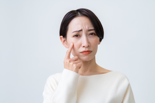 頬を指さす女性