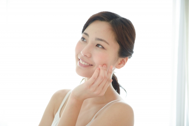 頬に手を当てる笑顔の女性