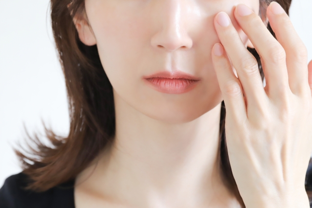 頬に手を当てる女性