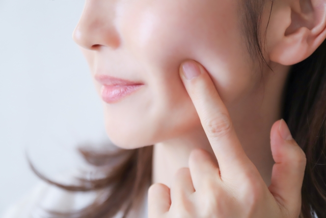 頬を触る女性