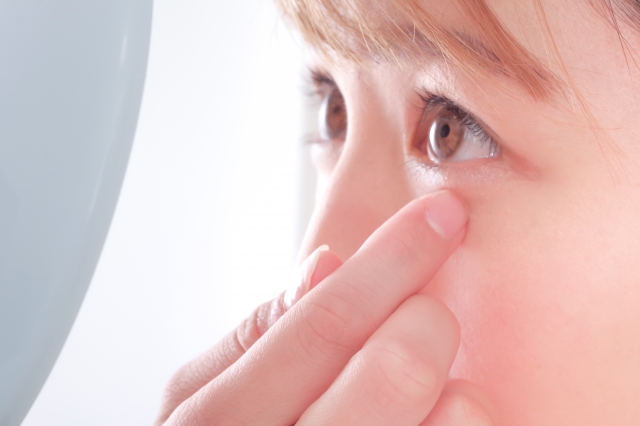 目元を触る女性