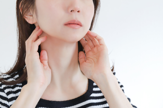 首元を触る女性