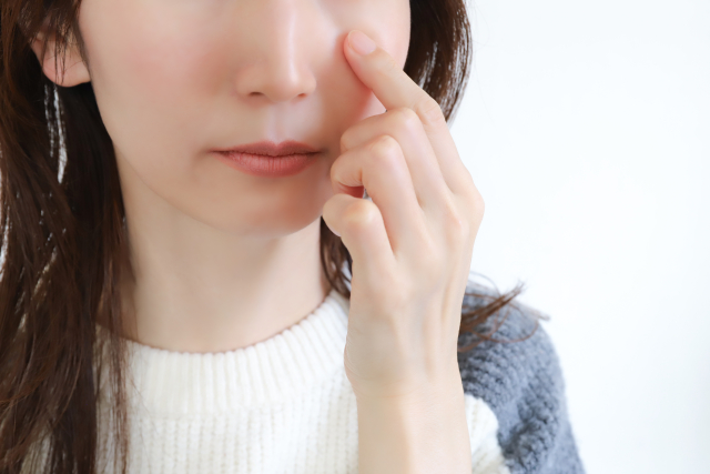 目元を触る女性